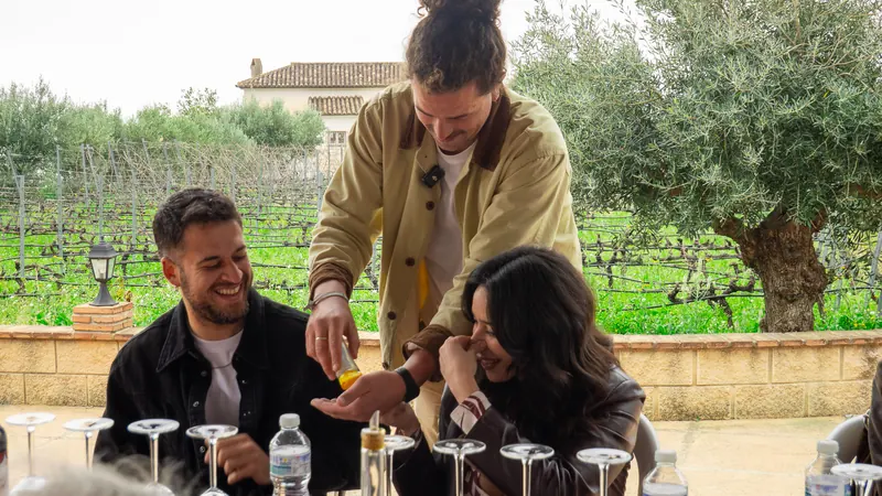 Host serving a smiling couple during their private vineyard tasting