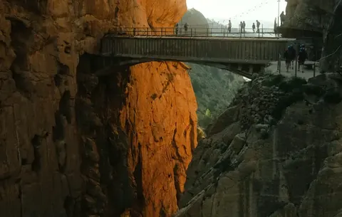 Walkers crossing a bridge inside the Caminito del Rey gorge near Málaga.