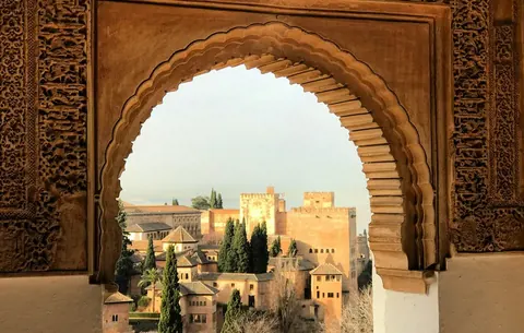 The Alhambra framed by a carved arch in Granada.