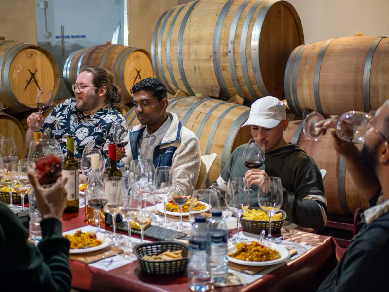 Guests enjoying food and wine in a winery room.