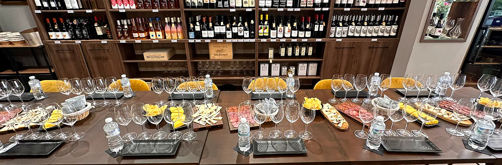 Tasting table prepared with wine glasses, cheeses, cured meats and individual place settings in central Málaga.
