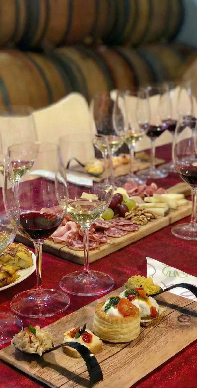 Tapas, local cheeses and wine glasses arranged on the tasting table inside Antonio Mérida’s winery.