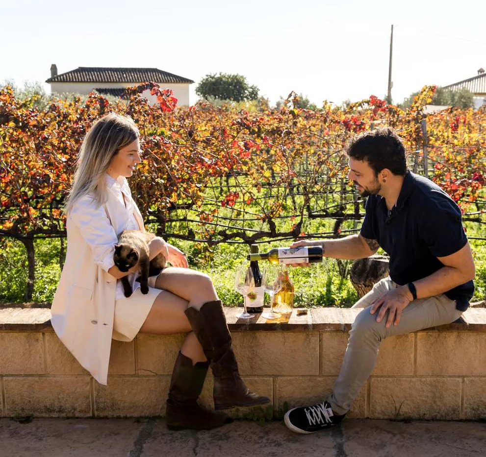 Two guests enjoying wine beside Antonio Mérida’s vineyard in the hills above Málaga.