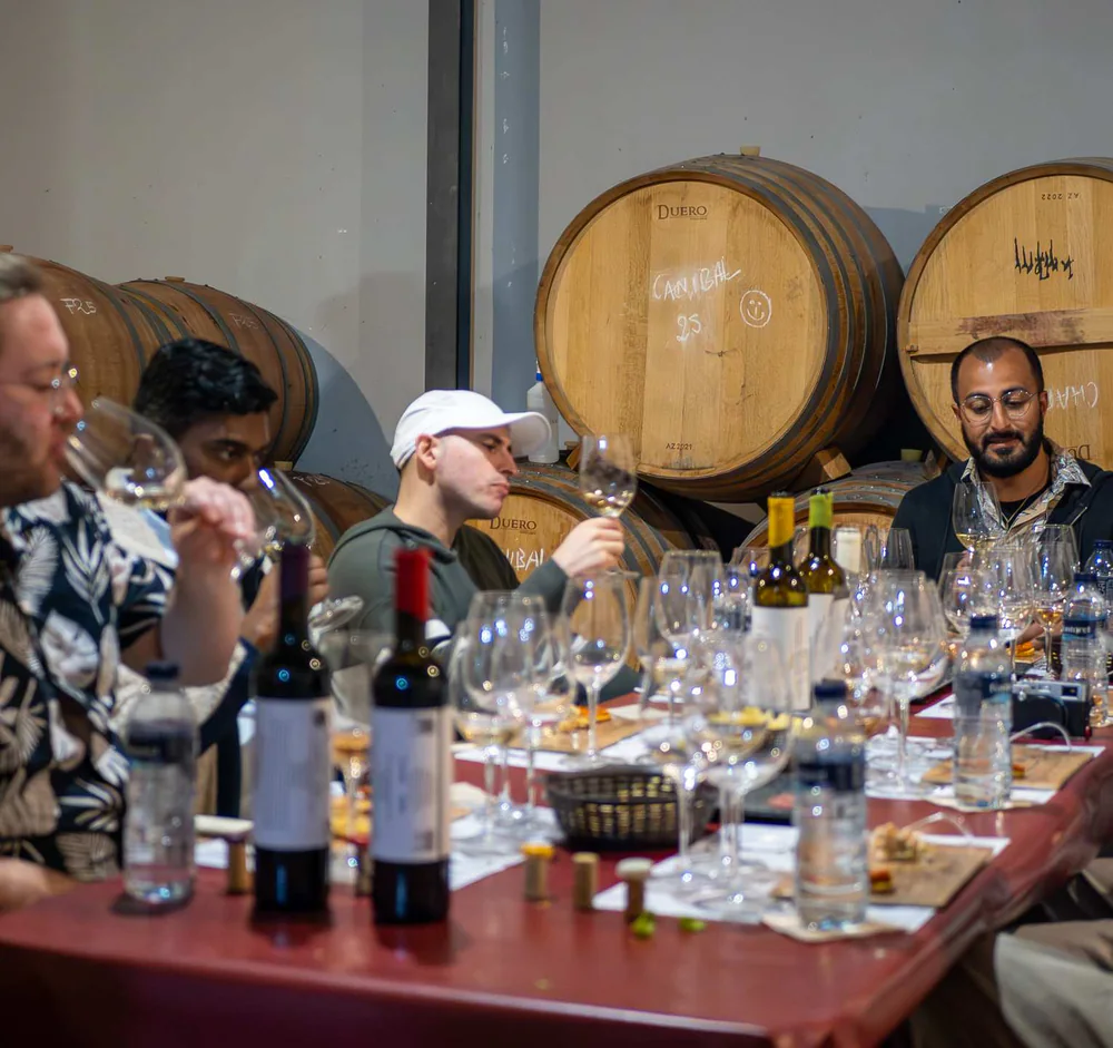 Small group sharing wines around the table inside Antonio Mérida’s barrel room.