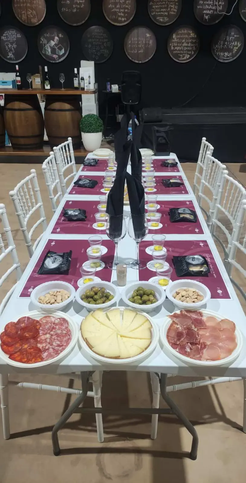 Long tasting table prepared with individual olive oil samples, local tapas and wine glasses.