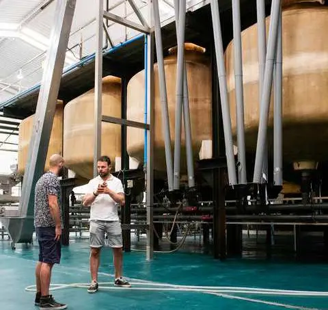 Guests learning beside the traditional tanks inside the working cooperative.