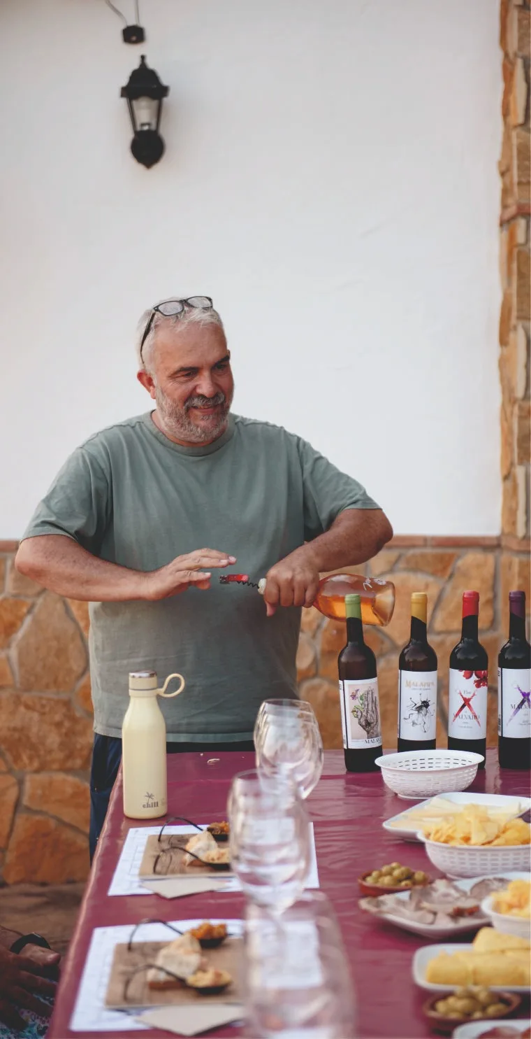 Antonio opening bottles at the vineyard tasting table.