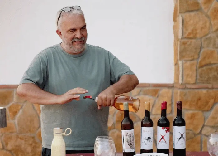 mijas-wine-tasting-owner-opening-rose-bottle.webp