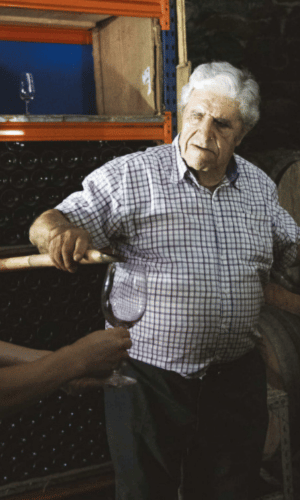 Winemaker pouring wine from barrel
