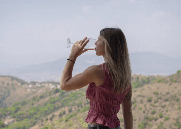 Woman enjoying a glass of wine with views of a vineyard in Málaga